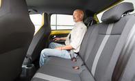 Ein Mann sitzt im Fond des VW Up (2016).