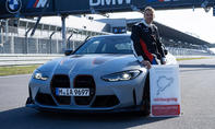 BMW M4 CSL fährt Nordschleifen-Rekord: Bild zeigt Fahrer Jörg Weidinger mit Rekordschild am Fahrzeug.