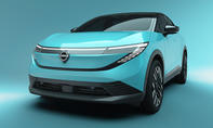 Der Nissan Leaf (2025) steht vor türkisem Hintergrund, von vorne fotografiert.