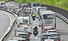 Stau auf der Autobahn, Motorradfahrer fahren zwischen den Autos durch.