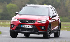 Der Seat Arona (2017) fährt durch eine Rechtskurve, von vorne fotografiert.