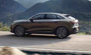 Audi Q3 Sportback 2025 fahrend im Gebirge, fotografiert von der Seite.