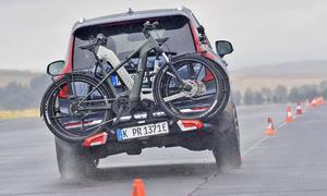 Das fahrdynamische Foto zeigt den beladenen Thule Fahrradträger Easyfold 3 beim Slalom auf der Teststrecke.