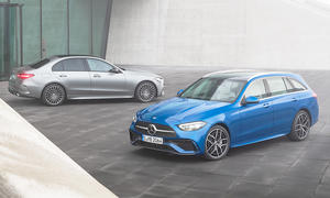 Die Mercedes C-Klasse steht als T-Modell und Limousine nebeneinander vor einem modern gestalteten Gebäude.