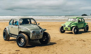 Zwei VW Twisted Tbug am Strand, fotografiert von schräg vorne.