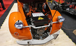 Ein Citroen 2CV mit geöffneter Motorhaube. Darunter sind Komponenten eines Elektroantriebs zu erkennen.