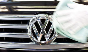 VW-Logo am Kühlergrill wird poliert