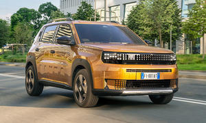 Der Fiat Grande Panda Hybrid (2025) fährt durch eine Stadt, von vorne rechts fotografiert.