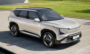 Der Kia EV5 (2025) steht in einer Einfahrt, von vorne rechts fotografiert.
