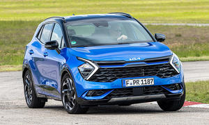 Der Kia Sportage (2021) fährt durch eine Linkskurve, von vorne rechts fotografiert.