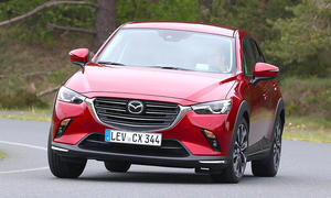 Der Mazda CX-3 (2018) fährt eine Rechtskurve, von vorne fotografiert.