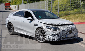 Der Mercedes-AMG CLA EQ (2025) biegt als Erlkönig in eine Einfahrt ein, von vorne rechts fotografiert.