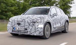 Der Mercedes GLC EQ (2026) fährt als Erlkönig eine Straße entlang, von vorne links fotografiert.