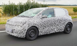 Der Renault Twingo E-Tech Electric (2026) fährt als Erlkönig auf einer Straße, von vorne links fotografiert.