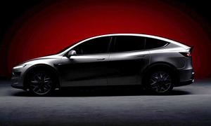 Das Tesla Model Y L (2025) steht im Halbdunkeln, von links fotografiert.