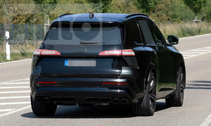 Der Audi SQ7 (2026) biegt als Erlkönig auf eine Landstraße ein, von hinten fotografiert.