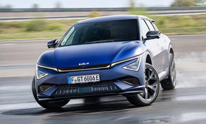 Das Kia EV6 GT Facelift (2025) driftend um eine Kurve, fotografiert von vorne.