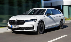 Der Skoda Superb iV Combi (2025) fährt durch die Hamburger Hafencity, fotografiert von schräg vorne.