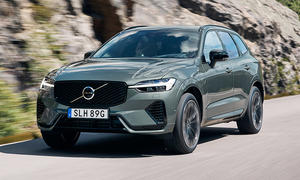 Der Volvo XC60 (2025) fährt auf einer Landstraße, von schräg vorne fotografiert.