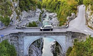 Camping-Reise durch Slowenien im VW T7 California; stehend auf einer Brücke über die Soča, Ansicht von seitlich oben