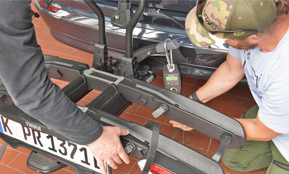Thule-Fahrradträger für bis zu drei E-Bikes im Test - Zbigniew Mazar Das Foto zeigt zwei Tester bei der Montage des Thule Fahrradträger Easyfold 3 an die Anhängerkupplung des Testwagens.