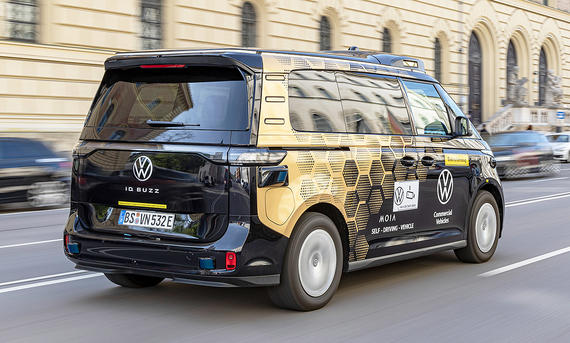 VW ID. Buzz AD (2026) - VW Der VW ID. Buzz AD (2026) fährt durch eine urbane Gegend, von hinten rechts fotografiert.