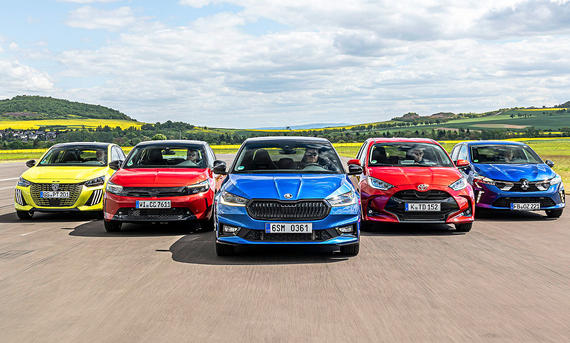 Peugeot 208/Opel Corsa/Skoda Fabia/Toyota Yaris/Mitsubishi Colt - Frank Ratering Gruppenbild der fünf Kleinwagen Peugeot 208, Opel Corsa, Skoda Fabia, Toyota Yaris und Mitsubishi Colt, die Frontal und in Formation auf die Kamera zufahren.
