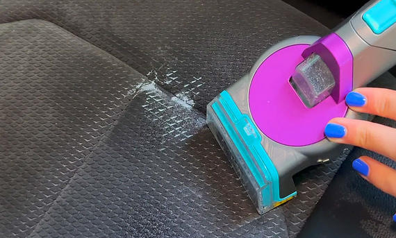 Shark StainStriker HairPro im Praxistest - Jamie Henry/Wunderweib Das Bild zeigt den Shark StainStriker HairPro im Praxistest. Autopolster werden mit dem Staubsauger gereinigt.