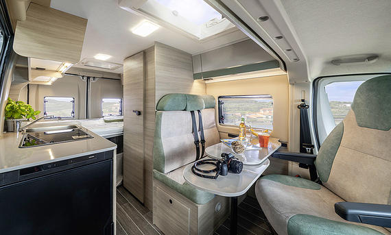 Forster Livin' Up Pro V 599 HBL (2025) - Forster Die Innenaufnahme zeigt die Sitzgruppe des Forster Livin' Up Pro V 599 HBL (2025)) mit Blick in Richtung Fahrzeugheck.