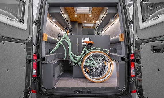 Das Bild zeigt die Heckgarage des Freedo M 599 (2025). Ein Fahrrad mit abmontiertem Vorderrad ist im Stauraum untergebracht.