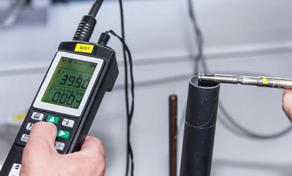 Aerometer bei der Messung der Saugleistung eines Industriestaubsaugers im Labor, fotografiert von schräg vorne.