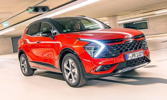 Blick von schräg vorne auf den fahrenden Kia Sportage.