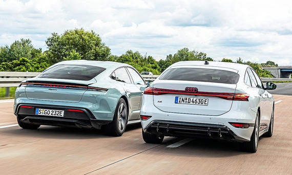 Blick von hinten auf die beiden Elektroautos Porsche Taycan und Audi A6 e-tron, die auf der Autobahn nebeneinander her fahren.