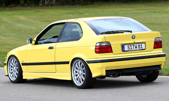 Der BMW E36 Compact fahrend von schräg hinten fotografiert. 