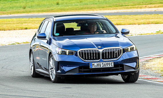BMW i5 Touring - Frank Ratering Blick von schräg vorne auf den BMW i5 Touring, der über eine Rennstrecke fährt.