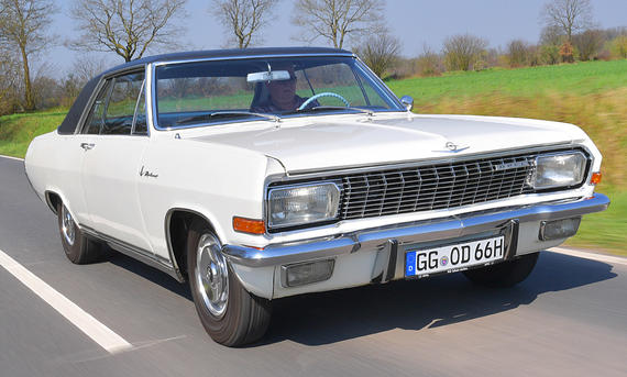 Der Opel Diplomat A V8 Coupé fahrend von schräg vorne fotografiert.