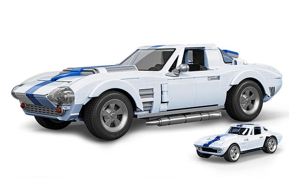 Das Bild zeigt die Mattel Brick Shop Chevrolet Corvette von schräg vorne links. Vor dem Klemmbaustein-Auto steht eine Diecast-Miniatur in kleinerem Maßstab.