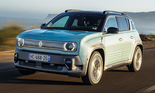 Der Renault 4 E-Tech Electric (2025) fährt eine Küstenstraße entlang, von vorne links fotografiert.
