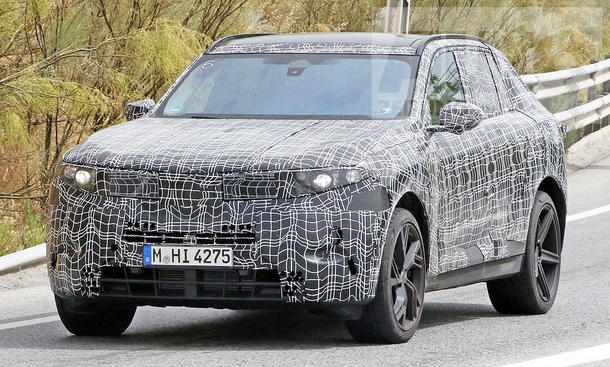 Der BMW X5 (2026) als Erlkönig fahrend von schräg vorne fotografiert.
