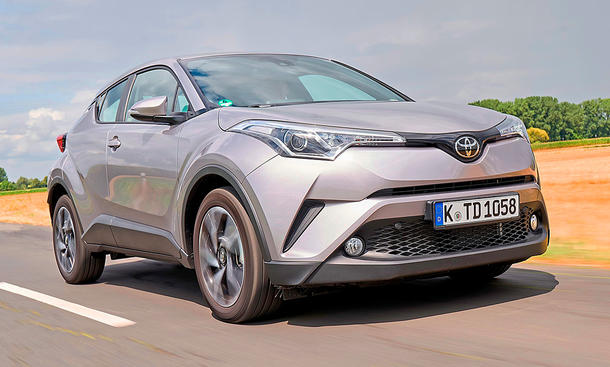 Der Toyota C-HR (2016) fährt auf einer Landstraße, von vorne rechts fotografiert.