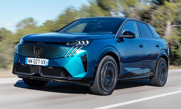 Der Peugeot E-3008 (2024) fahrend auf einer Straße von schräg vorne.