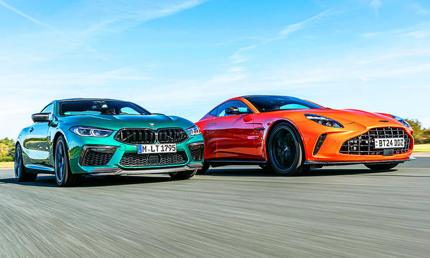 Der BMW M8 Competition & der Aston Martin Vantage V8 fahren nebeneinander auf der Rennstrecke her. Blick von vorne.