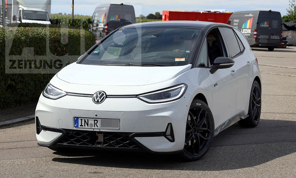 Ein Mule des Audi Q2 e-tron (2026) fährt mit der Karosserie eines VW ID.3 GTX um eine Rechtskurve, von vorne links fotografiert.
