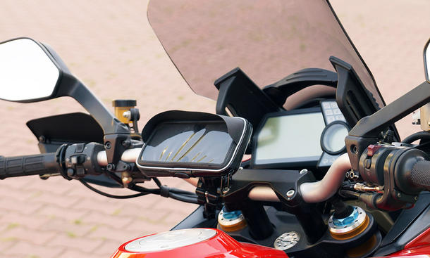 Ein Handyhalter fürs Motorrad mit Sonnenschutz, fotografiert an einem Motorrad mit Windschild.