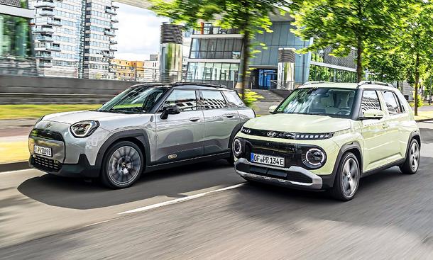 Blick von schräg vorne auf die fahrenden Elektro-Kleinwagen Mini Aceman und Hyundai Inster.
