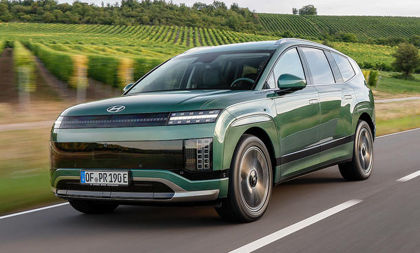 Der Hyundai Ioniq 9 (2025) fährt über eine Landstraße, von vorne links fotografiert.