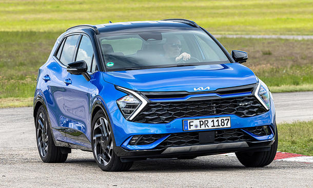 Der Kia Sportage (2021) fährt durch eine Linkskurve, von vorne rechts fotografiert.