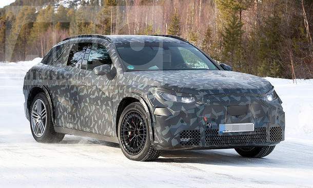 Das Mercedes-AMG SUV fährt als Erlkönig auf einer verschneiten Straße, von vorne rechts fotografiert.