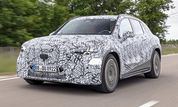 Der Mercedes GLC EQ (2026) fährt als Erlkönig eine Straße entlang, von vorne links fotografiert.