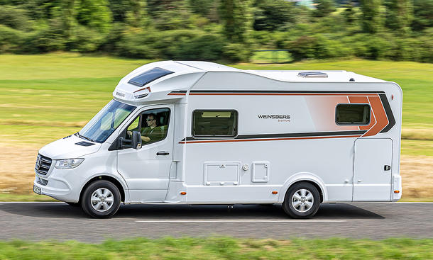 Weinsberg CaraCompact Suite MB 640 MEG Edition Pepper (2025) fährt auf einer Landstraße, Ansicht von der linken Seite.